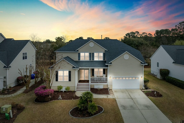 traditional home featuring a front lawn, driveway, covered porch, an attached garage, and a shingled roof