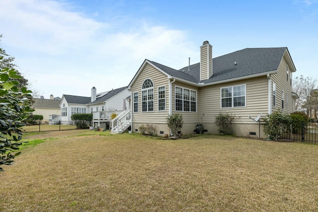 back of house featuring crawl space, a lawn, and fence