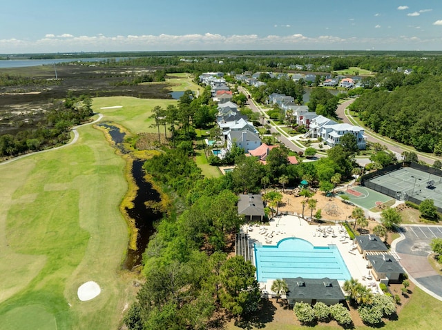 birds eye view of property with golf course view and a water view