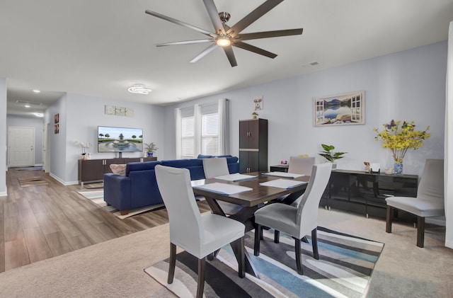 dining area with baseboards, visible vents, a ceiling fan, and wood finished floors