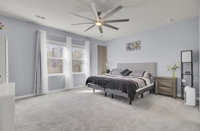 carpeted bedroom featuring a ceiling fan, visible vents, and baseboards