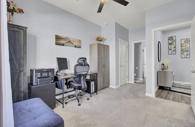 office featuring a ceiling fan, baseboards, and carpet flooring