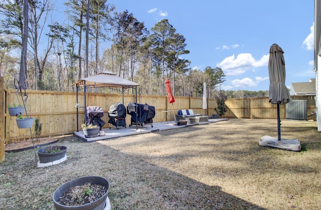 view of yard featuring a patio area, a fenced backyard, central AC, and a gazebo