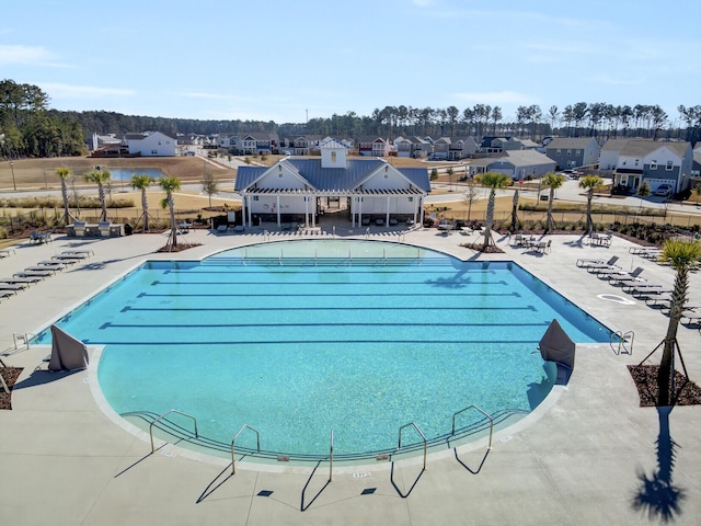 pool featuring a patio area, fence, and a residential view