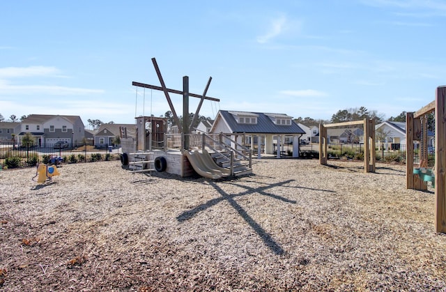 communal playground featuring fence and a residential view