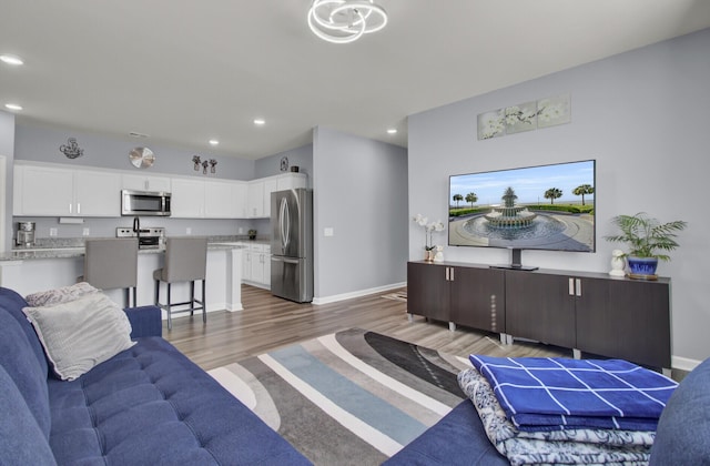 living room with recessed lighting, wood finished floors, and baseboards