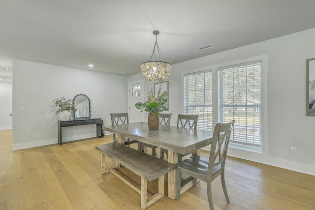 dining room featuring light wood-type flooring and a chandelier