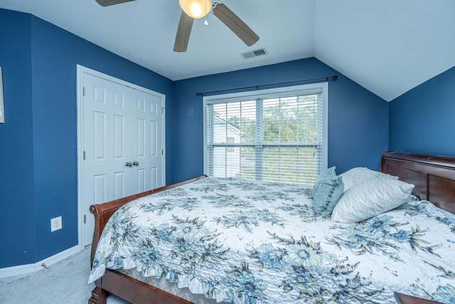 carpeted bedroom with a closet, vaulted ceiling, and ceiling fan