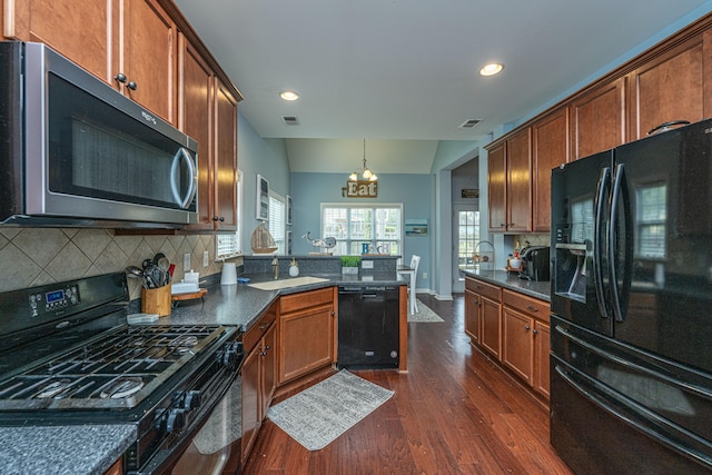 kitchen featuring black appliances, tasteful backsplash, dark hardwood / wood-style floors, vaulted ceiling, and a chandelier