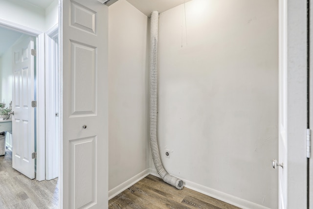 laundry area featuring electric dryer hookup and light hardwood / wood-style flooring