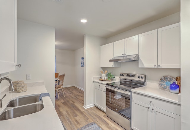 kitchen with white cabinets, sink, light wood-type flooring, and electric stove