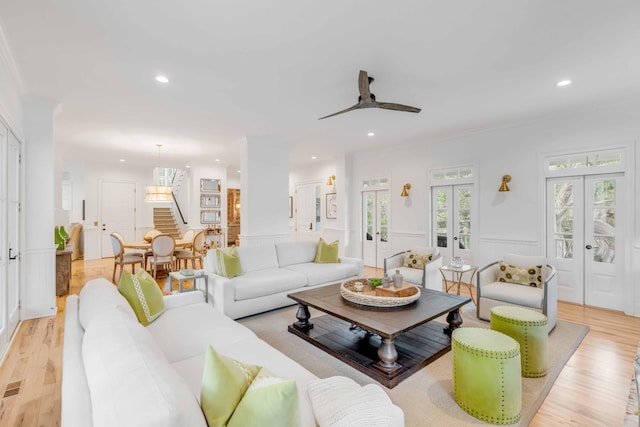 living room with french doors, light hardwood / wood-style flooring, ceiling fan, and crown molding