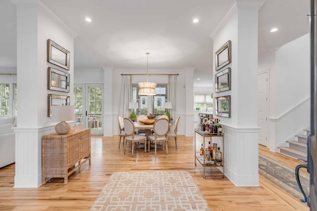 dining area featuring plenty of natural light, crown molding, and light hardwood / wood-style flooring