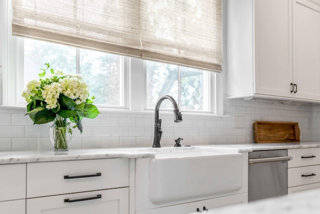 kitchen featuring decorative backsplash, sink, and white cabinets