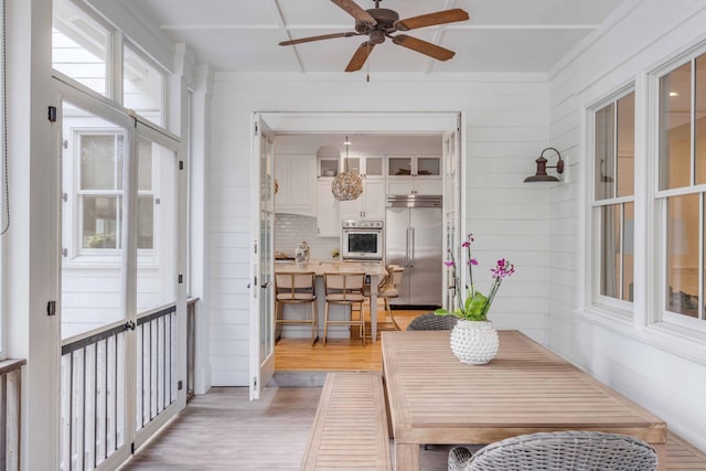 sunroom / solarium with ceiling fan and breakfast area