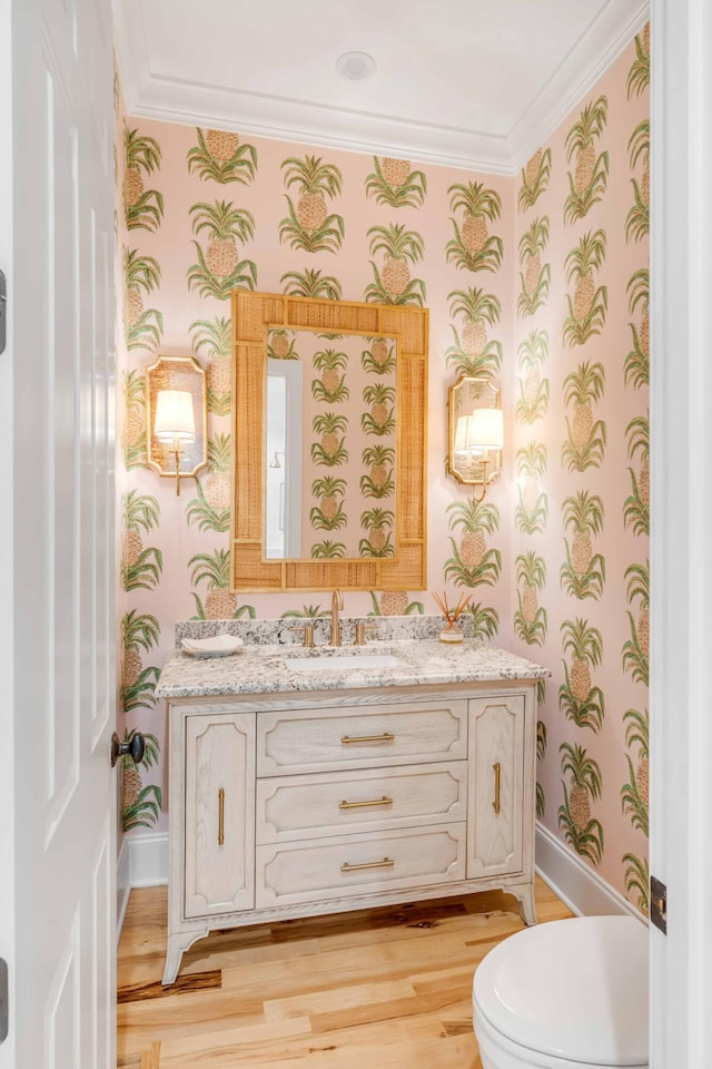 bathroom featuring vanity, hardwood / wood-style flooring, toilet, and crown molding