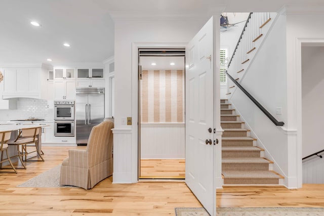 interior space with light hardwood / wood-style flooring and ornamental molding