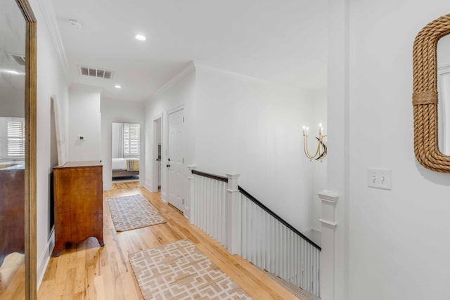 hall with light wood-type flooring and crown molding