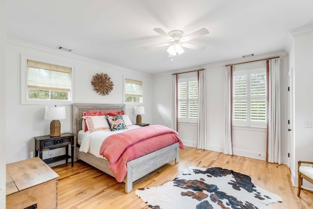 bedroom featuring multiple windows, wood-type flooring, ceiling fan, and crown molding