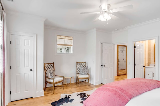 bedroom featuring ensuite bath, light hardwood / wood-style flooring, ceiling fan, and ornamental molding