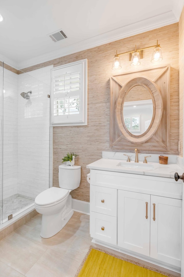 bathroom featuring vanity, tile patterned floors, toilet, ornamental molding, and tiled shower