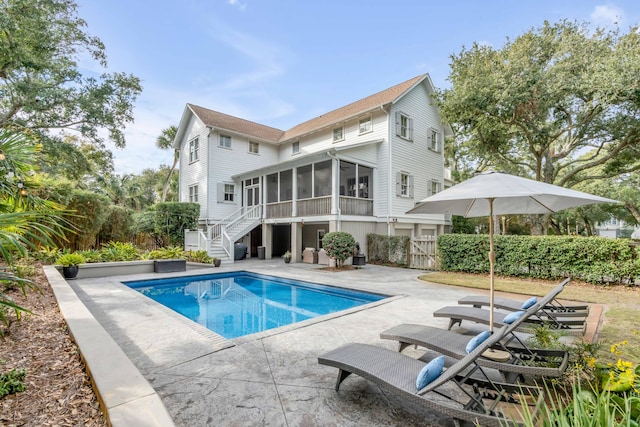 exterior space with a fenced in pool, a patio area, and a sunroom