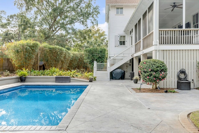 view of pool with a sunroom, ceiling fan, area for grilling, and a patio