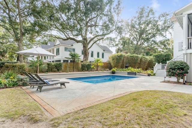 view of swimming pool with a yard and a patio