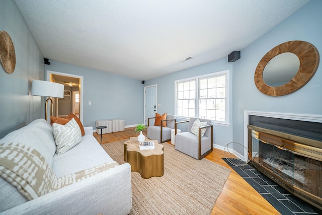 living room featuring dark hardwood / wood-style flooring, radiator, and a textured ceiling