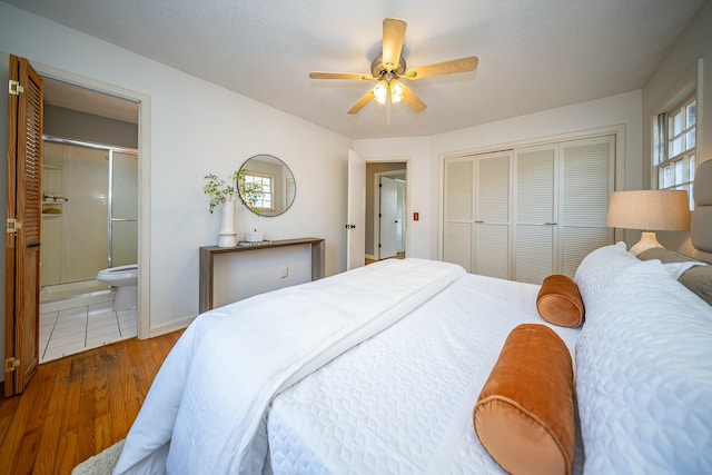 bedroom with connected bathroom, wood-type flooring, a closet, and ceiling fan