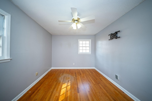 empty room featuring hardwood / wood-style floors, a textured ceiling, and ceiling fan