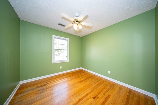 unfurnished room featuring ceiling fan, hardwood / wood-style floors, and a textured ceiling