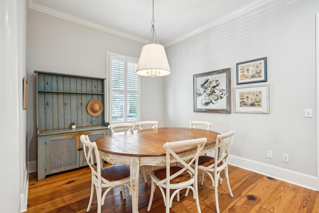 dining space with ornamental molding and hardwood / wood-style floors