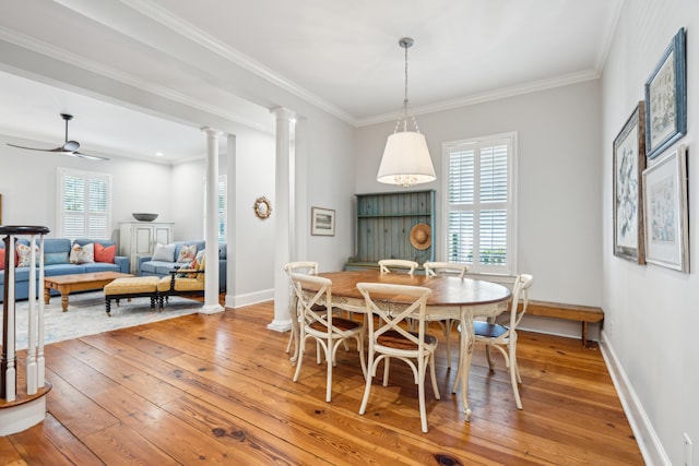 dining area with crown molding, ceiling fan, decorative columns, and hardwood / wood-style floors