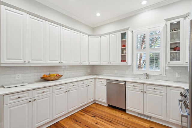 kitchen featuring white cabinetry, stainless steel appliances, crown molding, and light hardwood / wood-style flooring