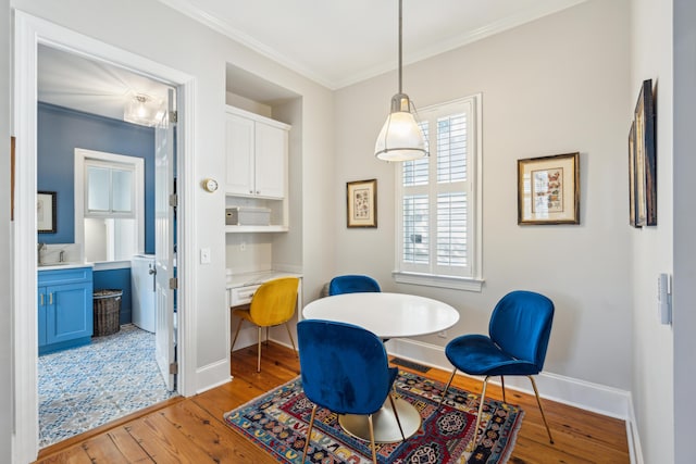 dining room with crown molding and light hardwood / wood-style floors