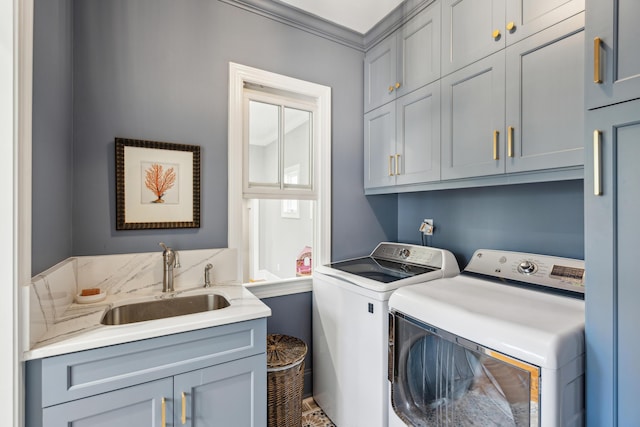 washroom featuring cabinets, ornamental molding, separate washer and dryer, and sink