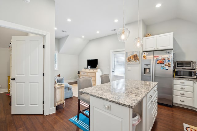 kitchen with stainless steel appliances, vaulted ceiling, a kitchen island, and white cabinets