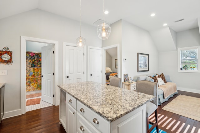 kitchen featuring lofted ceiling, white cabinetry, dark hardwood / wood-style floors, a kitchen island, and decorative light fixtures