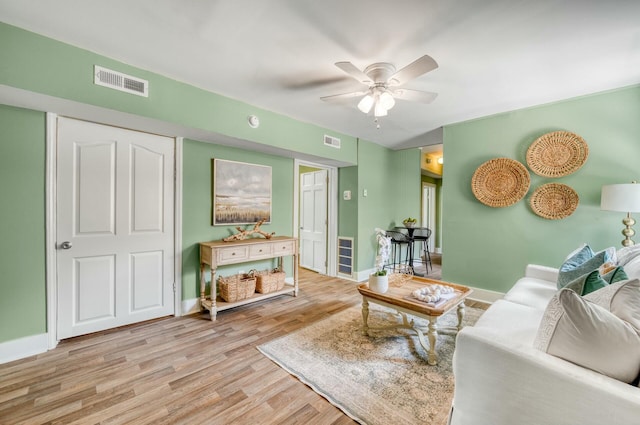 living room featuring light hardwood / wood-style floors and ceiling fan