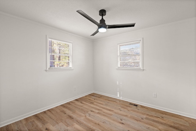 unfurnished room with light hardwood / wood-style flooring, a wealth of natural light, and ornamental molding