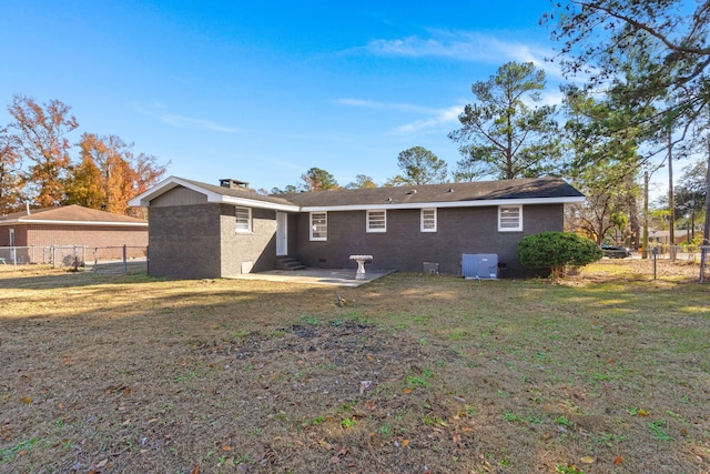 rear view of property with a yard and central air condition unit