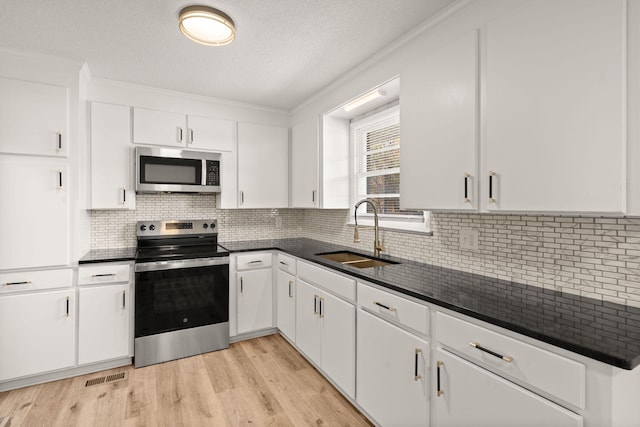 kitchen featuring sink, stainless steel appliances, light hardwood / wood-style flooring, white cabinets, and ornamental molding