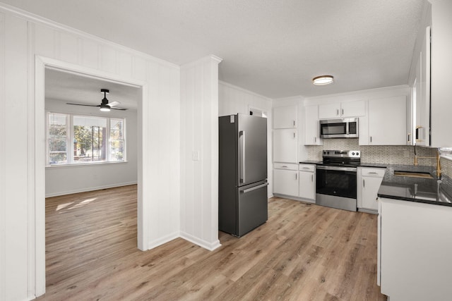 kitchen with white cabinetry, ceiling fan, light hardwood / wood-style flooring, backsplash, and appliances with stainless steel finishes