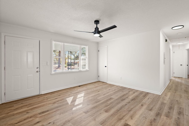 foyer entrance featuring ceiling fan, light hardwood / wood-style floors, ornamental molding, and a textured ceiling