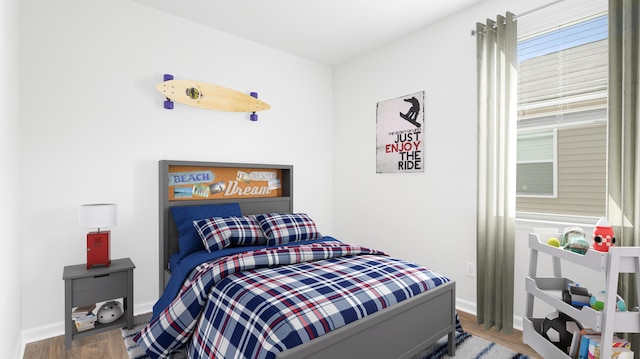 bedroom featuring baseboards and wood finished floors