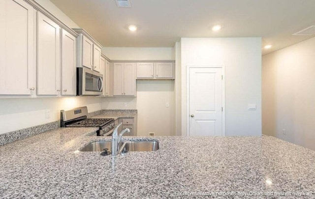 kitchen with light stone counters, visible vents, recessed lighting, a sink, and stainless steel appliances