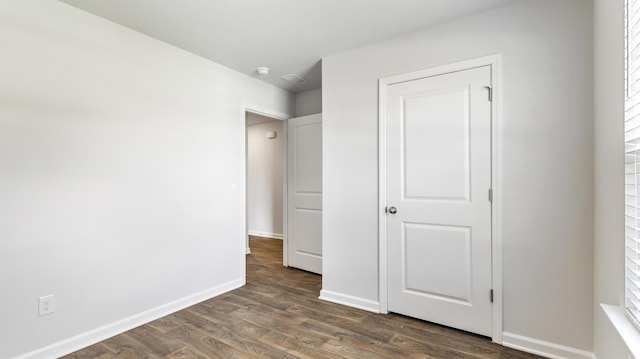 unfurnished bedroom featuring dark wood-type flooring and baseboards