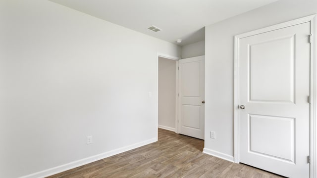 unfurnished bedroom with baseboards, visible vents, and light wood-type flooring