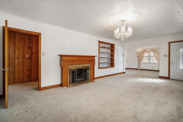 2830 Wire Rd, Saint George, SC 29477 - unfurnished living room with an inviting chandelier, a textured ceiling, a fireplace, and light carpet